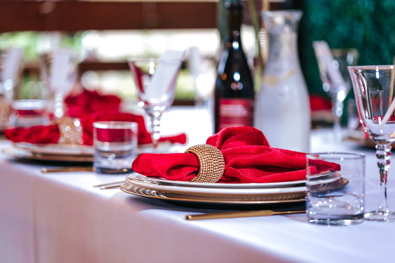 Private Dining Table Setting Private dining table with white linens, red napkins and gold chargers at JC Bruno