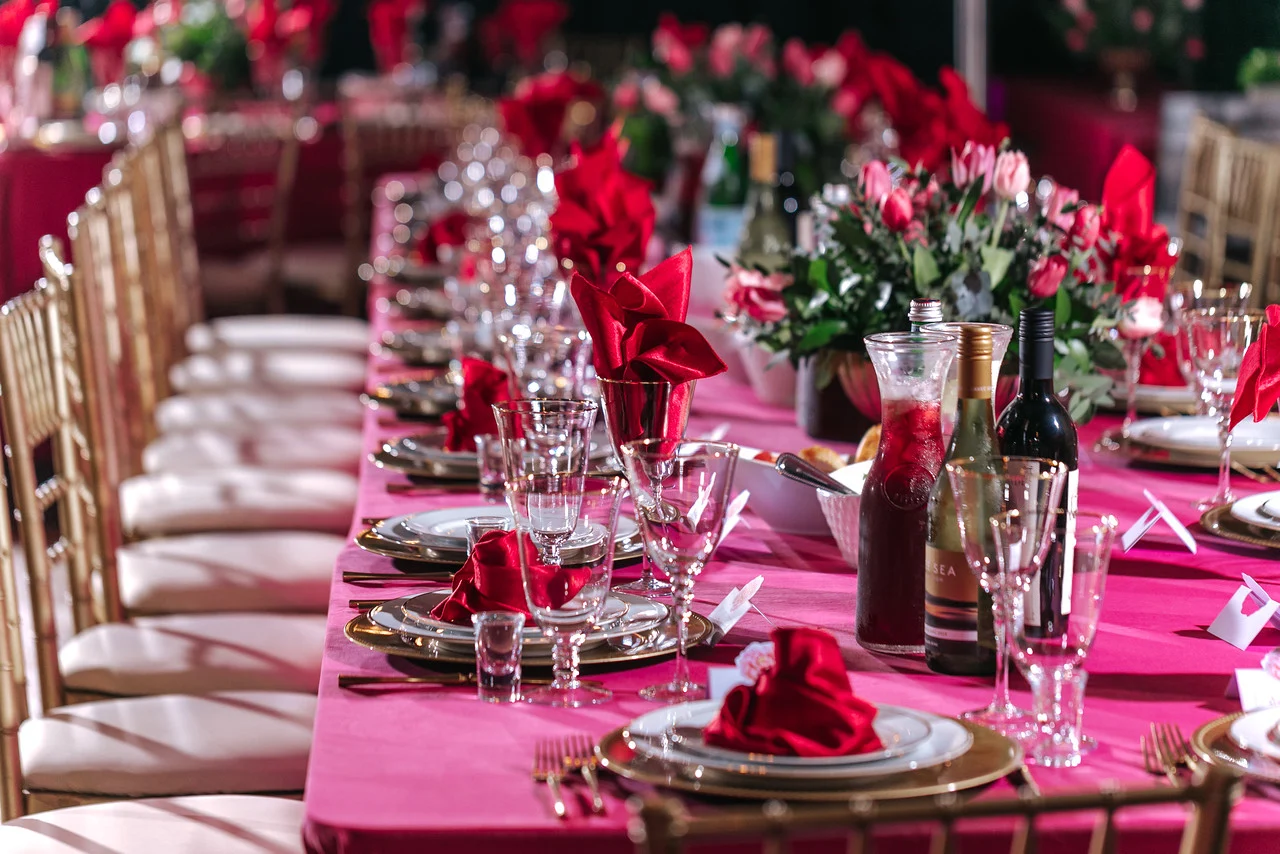 Private Party Banquet Table Banquet table with pink linens, red roses and gold chairs set for a private celebration